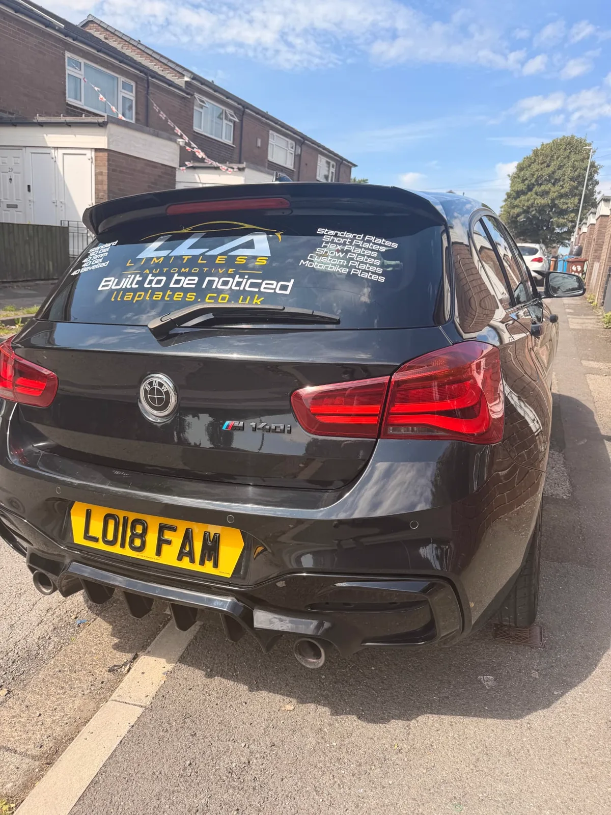 Black BMW M140i with a yellow 4D number plate by LLA Plates